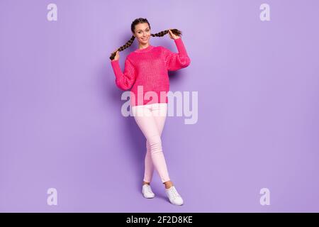 Foto a dimensione intera di giovane attraente grazioso dolce carino bella ragazza tirare due trecce isolate su sfondo di colore viola Foto Stock