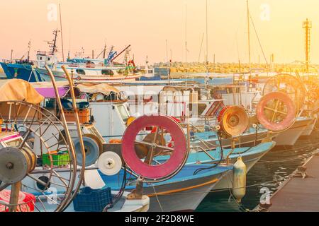 Barche da pesca e yacht al tramonto nel vecchio porto di Limassol, Cipro. Mar Mediterraneo e cultura greca. Foto Stock