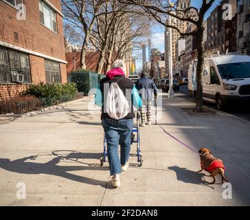 La donna anziana con il suo camminatore cammina il suo cane a Chelsea a New York giovedì 4 marzo 2021. (© Richard B. Levine) Foto Stock