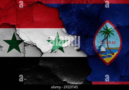 Bandiere di Siria e Guam dipinte su pareti incrinate Foto Stock