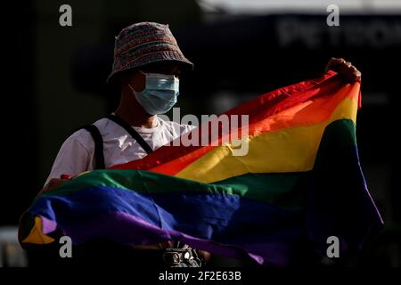 Una donna detiene una bandiera arcobaleno come membri di un gruppo LGBT (Lesbians Gays Bisexual Transgender) protesta contro la liberazione precoce del soldato statunitense Joseph Scott Pemberton al Boy Scout Circle a Quezon City, Metro Manila, Filippine. Foto Stock