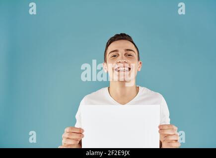 Bel ragazzo con foglio bianco di carta pubblicità mockup Copia Spazio Foto Stock