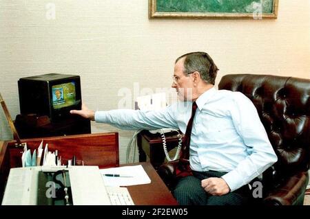 Il presidente George H. W. Bush guarda la copertura televisiva dell'inizio dell'operazione Desert Storm nello studio Oval Office. Foto Stock