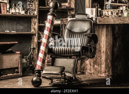 Elegante sedia barbiere vintage. Stylist professionale in interni barbershop. Sedia da barbiere. Poltrona per barbiere, parrucchiere moderno e capelli Foto Stock