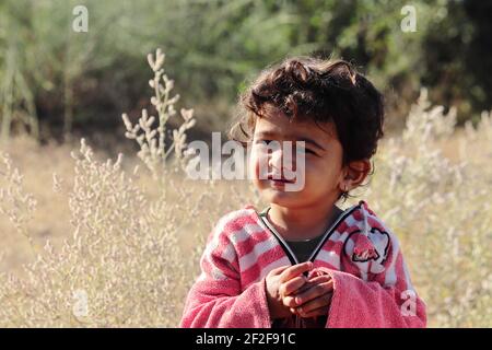 Un piccolo ragazzo di origine indiana che guarda la macchina fotografica con piccoli occhi.concetto per i bambini di oggi il futuro di domani, ricordi d'infanzia, sorriso sul viso, Foto Stock