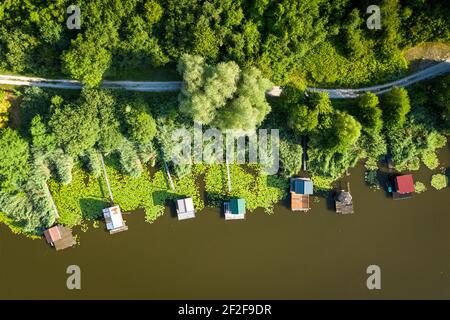 Direttamente sopra la vista dal drone sulle case dei pescatori palafitte sulla riva del lago, Albe Lacs, Sarreguemines, Francia. Foto Stock