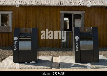 Moderni bidoni dei rifiuti su un vecchio edificio di sfondo a Moskenes Lofoten Foto Stock
