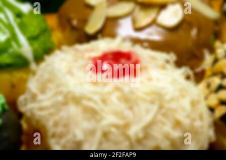 Sfondo astratto sfocato di formaggio spruzzato mini ciambella e rosso berry Foto Stock