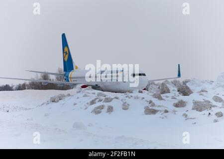 Ucraina, Kiev - 12 febbraio 2021: Aerei in inverno. Velivolo. C'è molta neve all'aeroporto. Cattive condizioni meteorologiche e visibilità. Blocchi di neve. Nevicate. C'è molta neve all'aeroporto. Foto Stock