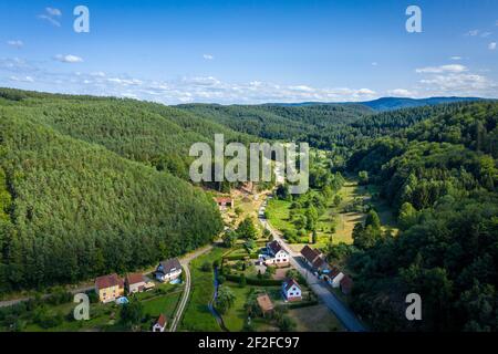 Vista aerea della campagna francese. Piccolo villaggio con diverse case tra boschi. Estate paesaggio foto da drone. Foto Stock
