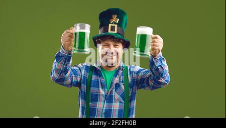 Uomo irlandese in cappello di Patrick con due birre allevate isolate su spazio copia verde Foto Stock