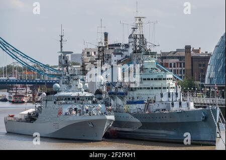 HMS Tamar una nuova nave di pattuglia è ormeggiata vicino a HMS Belfast sul fiume Tamigi tra il Tower Bridge e il London Bridge. È la quarta delle cinque nuove navi di pattuglia offshore costruite per sostituire le navi della River Class. Foto Stock