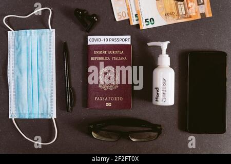 concetto di viaggio d'affari con passaporto di vaccinazione covid con passaporto di immunità covid19. disinfettante per le mani e telefono cellulare e denaro con maschera facciale, t Foto Stock