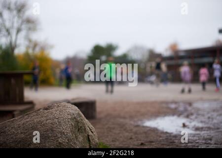 Bambini che giocano sul parco giochi in background a scuola Foto Stock