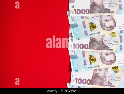 Mille banconote ucraine di hryvnia su sfondo rosso 2 Foto Stock