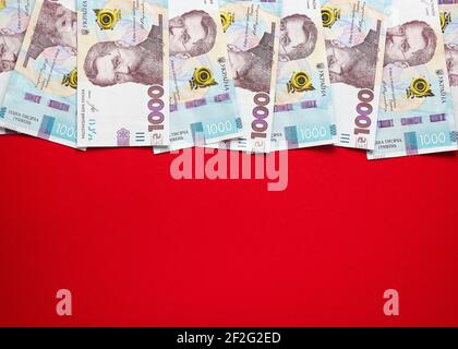 Mille banconote ucraine di hryvnia su sfondo rosso Foto Stock