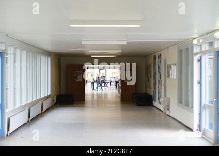 Un corridoio della scuola con i bambini che giocano a ping-pong lungo la sala Foto Stock