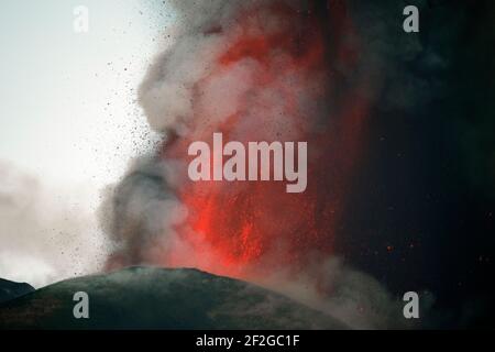 CATANIA, ETNA, ITALIA - 12 MARZO 2021: Nuova eruzione del vulcano Etna in sicilia. Fontane di lava e un enorme pennacchio di gas e cenere piroclastica dal Cratere di sudest. Foto Stock