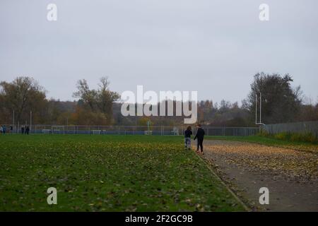 Due bambini piccoli che camminano su un campo su un cupo giorno Foto Stock