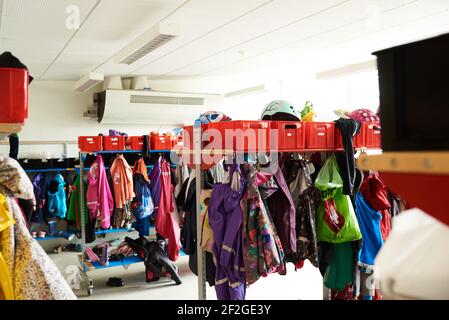 appendiabiti scuola elementare con abiti colorati appesi ai ganci Foto Stock