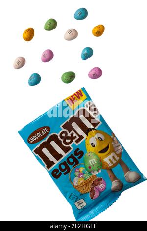 Confezione di cioccolatini M&M's eggs aperta con contenuto versato su sfondo bianco M&MS eggs Chocolate Foto Stock