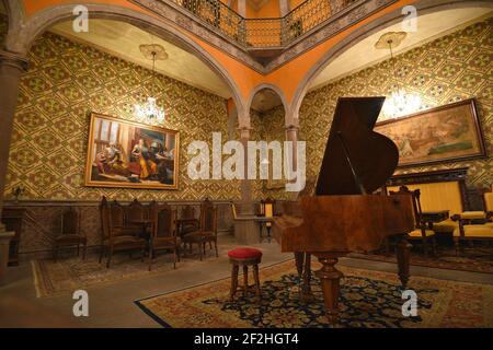 Vista interna del Museo Palacio de San Agustín in stile coloniale con archi, colonne in pietra e il pianoforte in primo piano a San Luis Potosí Messico. Foto Stock