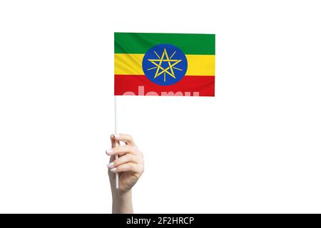 Bella mano femminile che tiene bandiera di Etiopia, isolato su sfondo bianco. Foto Stock
