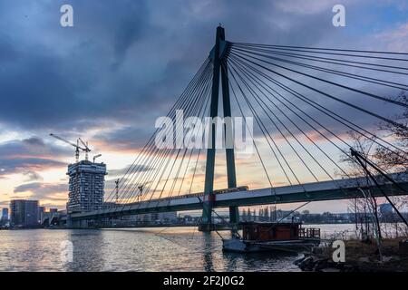 Vienna, il ponte della metropolitana Donaustadtbrücke, la linea U2 della metropolitana, il fiume Donau (Donau), la barca da pesca con Daubel (rete di sollevamento), Marina Tower in costruzione nel 02. Leopoldstadt, Vienna, Austria Foto Stock