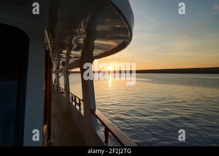 splendido e spettacolare tramonto su uno yacht a motore con riflessi sulla vernice bianca e dettagli dell'imbarcazione, sdraiato nella baia di darwin di ge Foto Stock