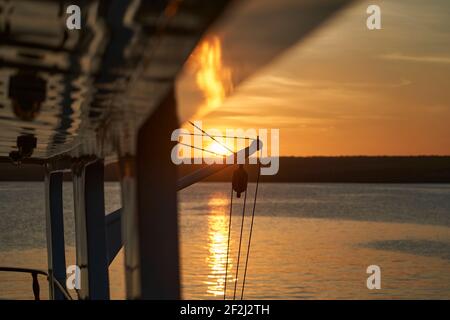 splendido e spettacolare tramonto su uno yacht a motore con riflessi sulla vernice bianca e dettagli dell'imbarcazione, sdraiato nella baia di darwin di ge Foto Stock