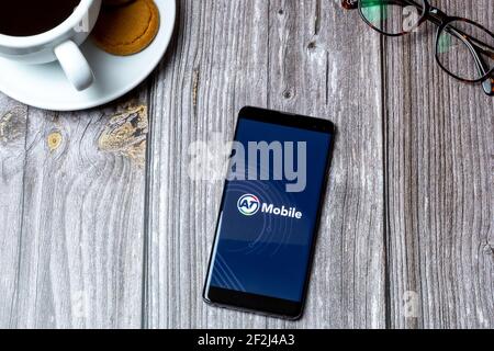 Un telefono cellulare o un telefono cellulare posato su un legno Tavolo con l'app AT Mobile aperta sullo schermo Foto Stock