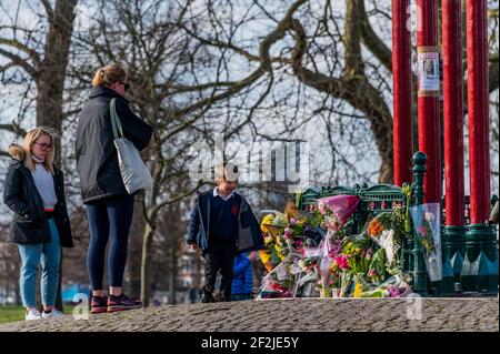 Londra, Regno Unito. 12 marzo 2021. La gente ha cominciato a lasciare i fiori e i tributi per Sarah Everard alla Bandstand dove sperano di avere una veglia domani sera, anche se questo è attualmente vietato dalla polizia in base a norme covide. Ci sono ancora i segni in su (che chiedono tutte le informazioni) fatti dagli amici interessati. Scomparve dopo le 9:00 del 3 marzo da qualche parte tra Clapham Junction e Brixton. Credit: Guy Bell/Alamy Live News Foto Stock