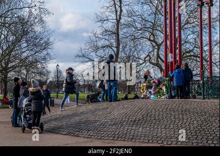 Londra, Regno Unito. 12 marzo 2021. La gente ha cominciato a lasciare i fiori e i tributi per Sarah Everard alla Bandstand dove sperano di avere una veglia domani sera, anche se questo è attualmente vietato dalla polizia in base a norme covide. Ci sono ancora i segni in su (che chiedono tutte le informazioni) fatti dagli amici interessati. Scomparve dopo le 9:00 del 3 marzo da qualche parte tra Clapham Junction e Brixton. Credit: Guy Bell/Alamy Live News Foto Stock