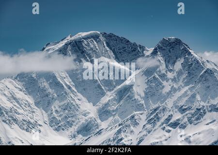 Idilliaco scatto di montagna innevata contro il cielo blu Foto Stock