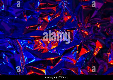 Astratto rosso e blu alluminio rugoso sfondo texture riflettenti luce rossa e blu Foto Stock