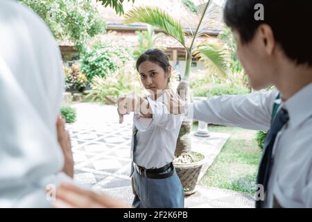 Una studentessa di scuola superiore in Indonesia era arrabbiata il dito che punta verso le studentesse e gli studenti maschi si è rotto Foto Stock