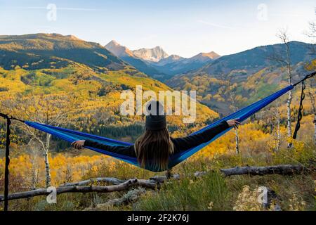Giovane donna con relax su amaca in foresta durante le vacanze Foto Stock