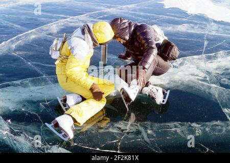 Madre e figlia siedono sul ghiaccio del lago Baikal Foto Stock