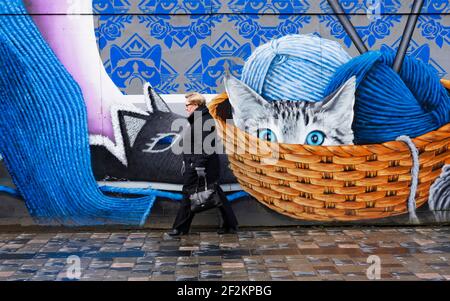 Glasgow, Scozia, Regno Unito. 12 marzo 2021. Il giorno il blocco Covid-19 è rilassato leggermente in Scozia le strade del centro città nel centro di Glasgow rimangono quasi deserte praticamente tutti i negozi e caffè sono ancora chiusi. PIC; membro del pubblico cammina oltre il murale impressionante su Sauchiehall Street. Iain Masterton/Alamy Live News Foto Stock