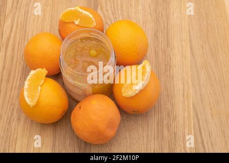 Deliziosa e fresca marmellata d'arancia con frutta intorno al vaso - arance a fette. Foto Stock