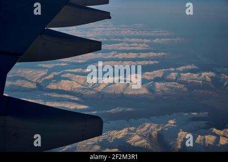 Ala di Airplane Jet sopra l'Islanda con le montagne e l'oceano atlantico con cielo blu, Islanda, Europa, Foto Stock