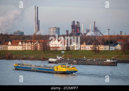 Duisburg, Renania Settentrionale-Vestfalia, Germania - paesaggio urbano nella zona della Ruhr con una nave da carico sul Reno di fronte a edifici residenziali nel distretto di Laar e sul retro l'altoforno 8 da ThyssenKrupp Huettenwerk a Brukhausen. Foto Stock