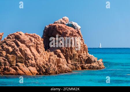 Le rocce rosse sul bordo settentrionale della lunga spiaggia chiamata Spiaggia di Cea, nei pressi di Arbatax (Sardegna, Italia) Foto Stock