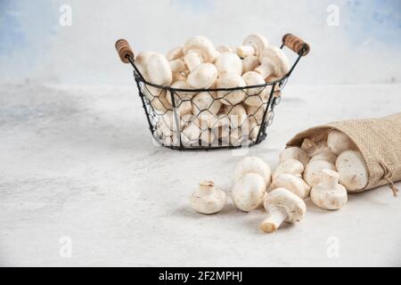 Funghi bianchi all'interno di cestini rustici e un vassoio metallico Foto Stock