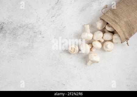 Funghi bianchi all'interno di cestini rustici su sfondo marmoreo Foto Stock