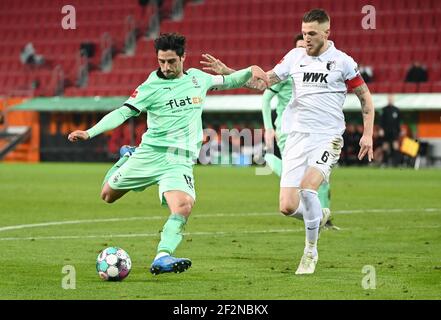 Augusta, Germania. 12 marzo 2021. Calcio: Bundesliga, FC Augusta - Borussia Mönchengladbach, Giornata 25 alla WWK Arena. Jeffrey Gouweleeuw (r) di Augsburg e Lars Stindl di Mönchengladbach combattono per la palla. NOTA IMPORTANTE: In conformità con le norme del DFL Deutsche Fußball Liga e del DFB Deutscher Fußball-Bund, è vietato utilizzare o utilizzare fotografie scattate nello stadio e/o della partita sotto forma di sequenze di immagini e/o serie di foto simili a video. Credit: Attias Balk/dpa/Alamy Live News Foto Stock