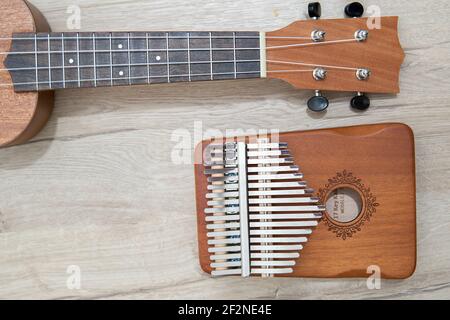 Kalimba 17 chiavi e ukulele su sfondo di legno nero. Strumento musicale africano. Pianoforte a pollice con copyspace. Foto Stock