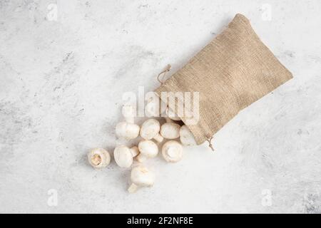 Funghi bianchi all'interno di cestini rustici su sfondo marmoreo Foto Stock