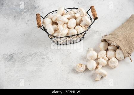 Funghi bianchi all'interno di cestini rustici e un vassoio metallico Foto Stock