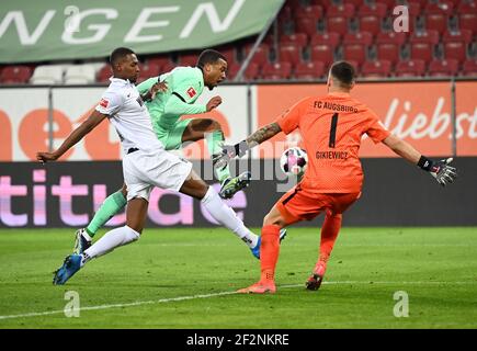 12 marzo 2021, Baviera, Augusta: Calcio: Bundesliga, FC Augusta - Borussia Mönchengladbach, Giornata 25 alla WWK Arena. Alassane plea (M) di Mönchengladbach cerca di affermarsi contro Felix Uduokhai (l) di Augusta e il portiere Rafal Gikiewicz. NOTA IMPORTANTE: In conformità con le normative della DFL Deutsche Fußball Liga e della DFB Deutscher Fußball-Bund (Associazione tedesca del calcio), è vietato sfruttare o sfruttare le fotografie scattate nello stadio e/o della partita sotto forma di sequenze di immagini e/o serie di foto di tipo video. Foto: Matthias Balk/dpa Foto Stock